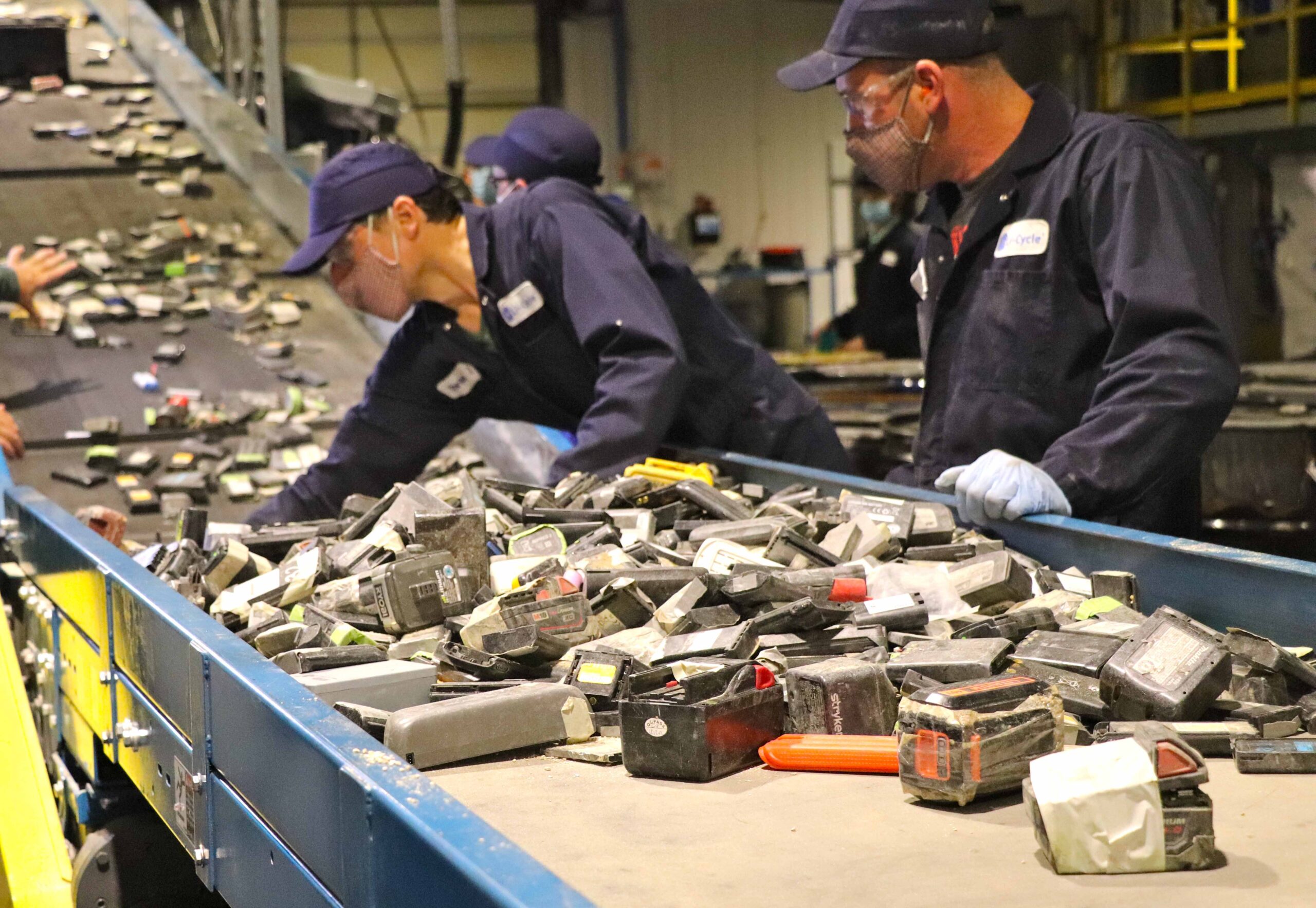 Li-Cycle employees feeding lithium-ion batteries to the shredder