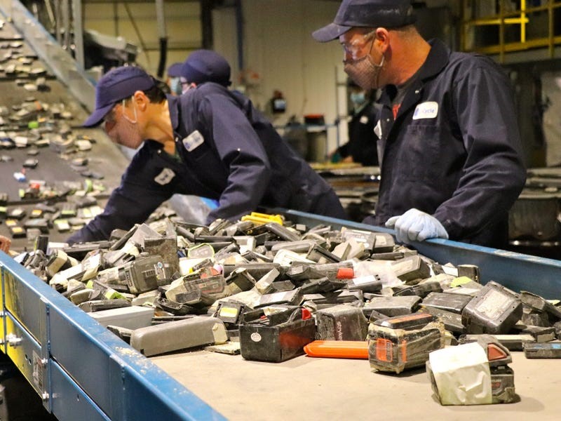 Li-Cycle employees feeding batteries into the shredder at Kingston Spoke