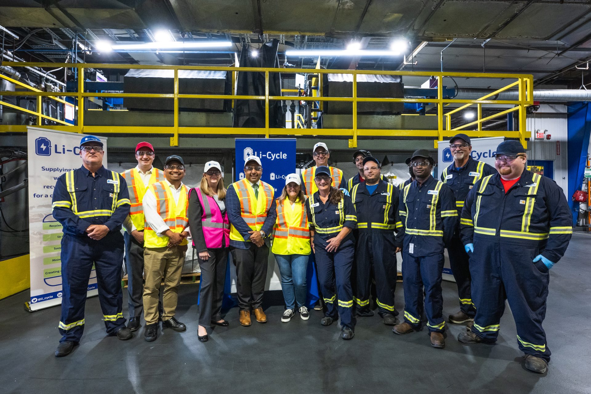 Group photo of Li-Cycle team members wearing safety gear inside industrial building with Li-Cycle President and CEO, co-founder, Ajay Kochhar and Deputy Prime Minister, Chrystia Freeland at the center of group photo.